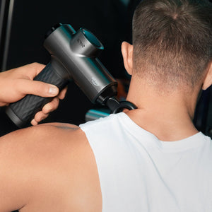 using deep tissue massage gun on shoulder muscle