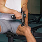 athlete applying percussion massage gun to thigh for recovery	